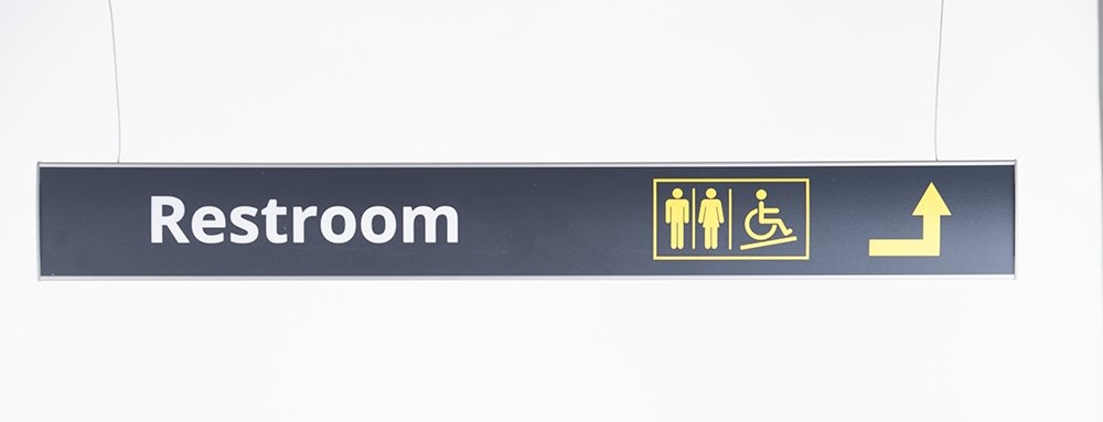 Directional lobby signage leading to elevators and reception